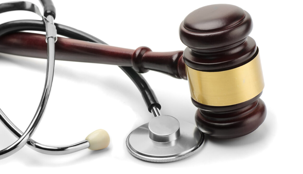 Close up of stethoscope and gavel on white background